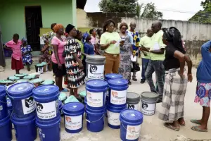 Community members gather around Bucket of Love buckets in Abia State, Nigeria
