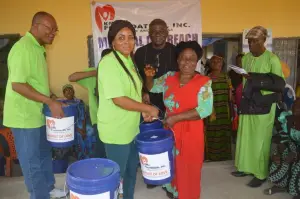 KMJ Foundation volunteers hand a Bucket of Love to a young woman