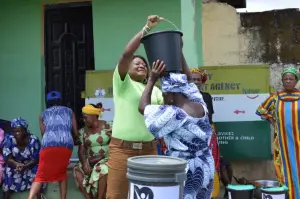 KMJ Foundation volunteer lifts a bucket during the 2023 distribution in Abia State