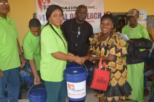 Smiling woman receives support from the KMJ Foundation team